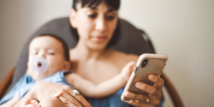 Baby sat on floor and holding a smart phone